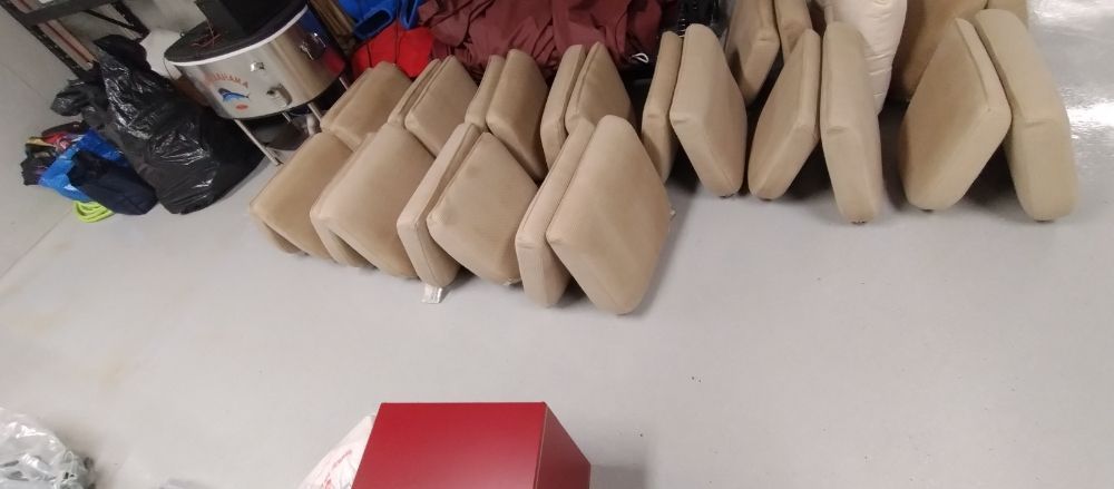 A bunch of cushions are stacked on top of each other on the floor.