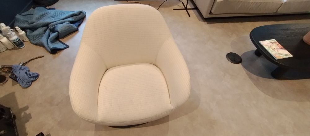 A white chair is sitting on the floor in a living room.