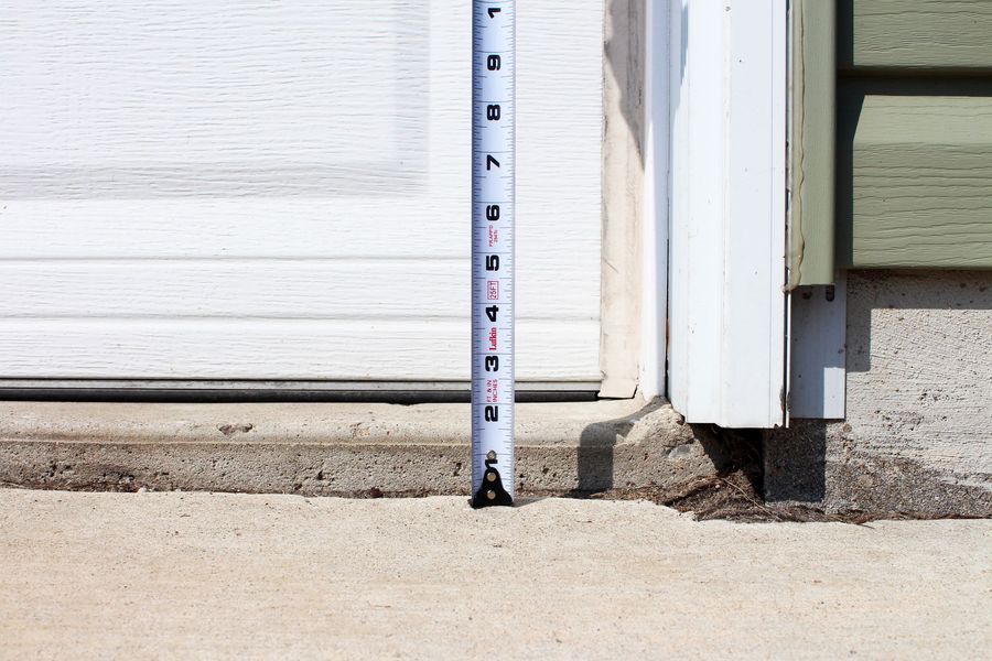 A tape measure is being used to measure the height of a garage door