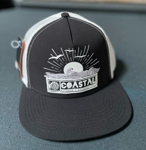 A black and white hat with the word coastal on it