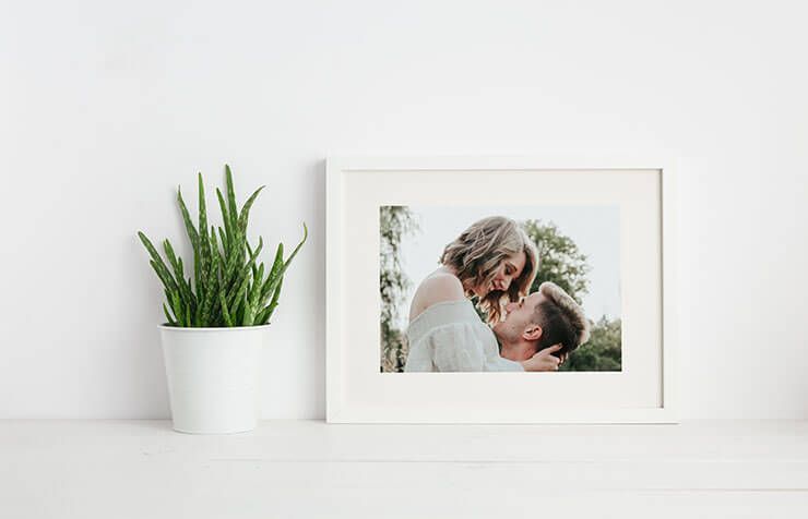 a pile of pictures, man in a trench coat and a woman in a chair
