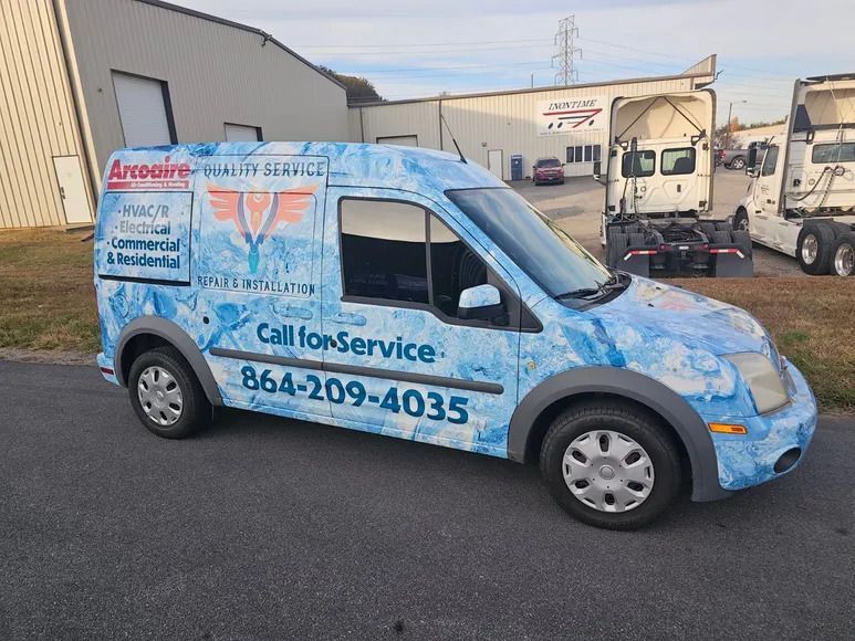 A blue van that says call for service is parked on the side of the road.