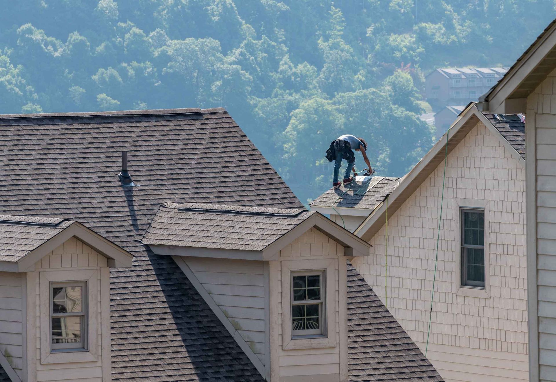 Young roofing contractor replacing the old shingles.