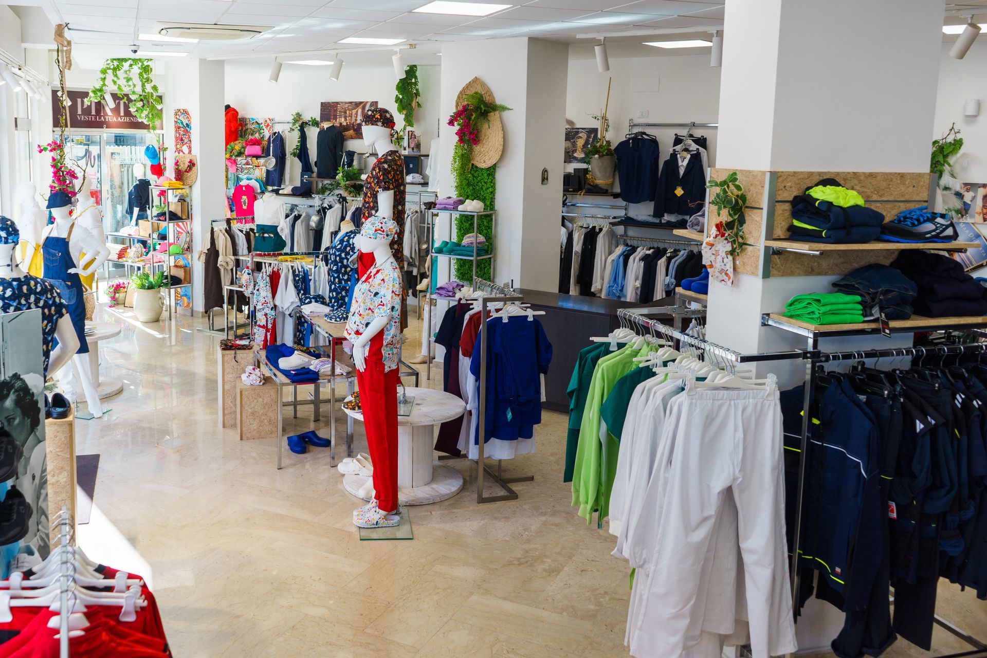 Interno di un negozio di abbigliamento con scaffali pieni di vestiti e manichini.