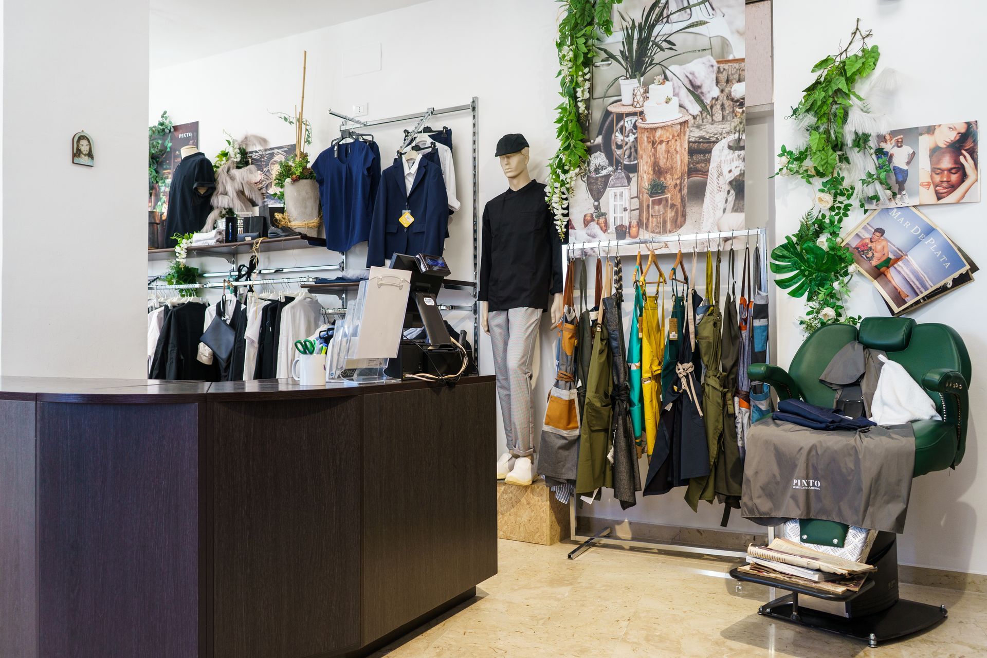 Interno di un negozio di abbigliamento con espositori per abiti, bancone per la cassa e manichino.