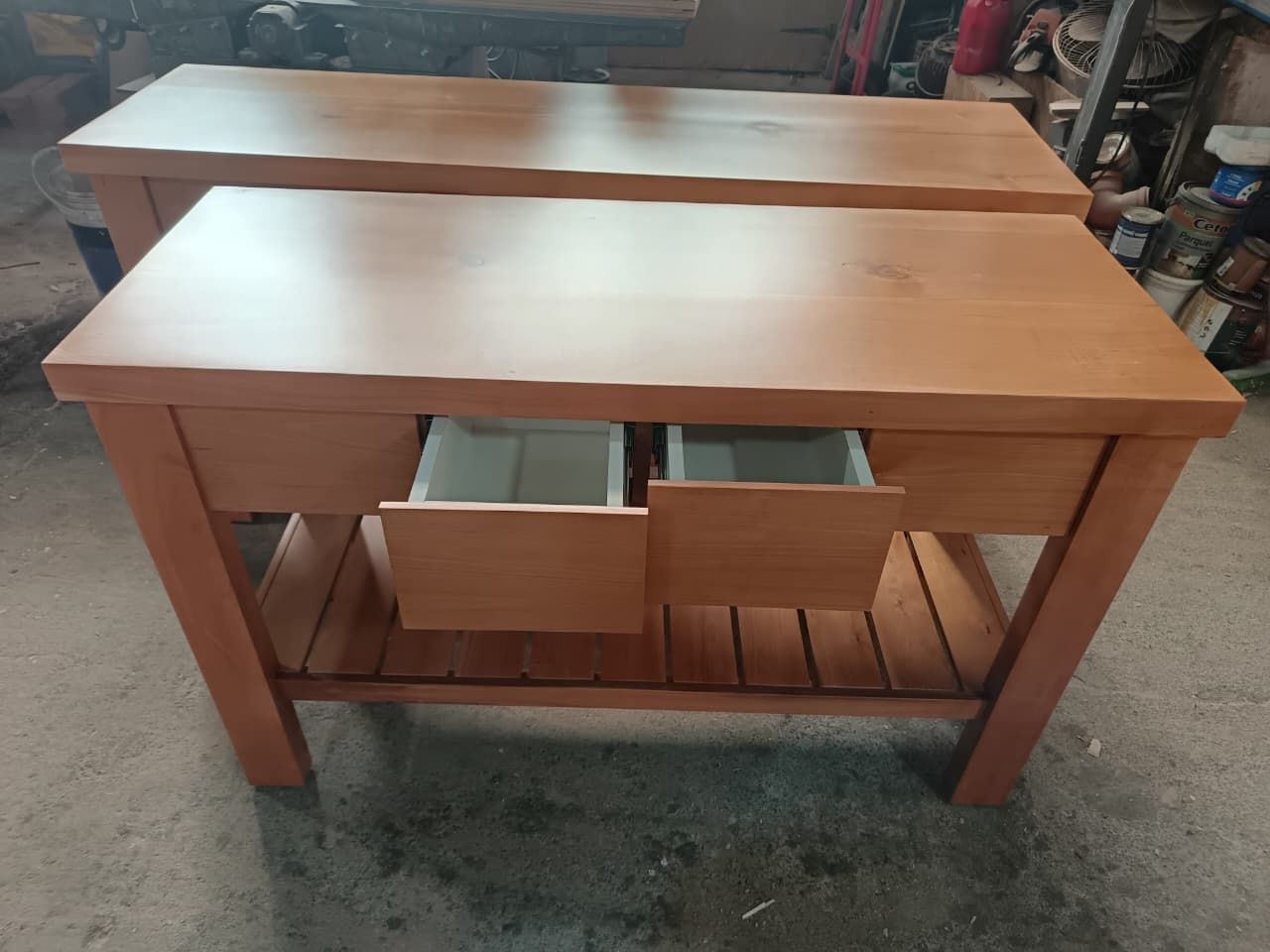 Mesa de madera con dos cajones extraíbles, mostrada en el suelo de un taller.