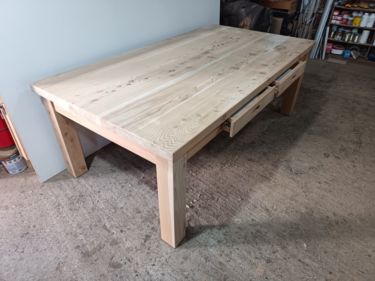 Muebles de madera hechos a medida con estantes blancos divididos en secciones, sobre una pared lisa y suelo de baldosas.