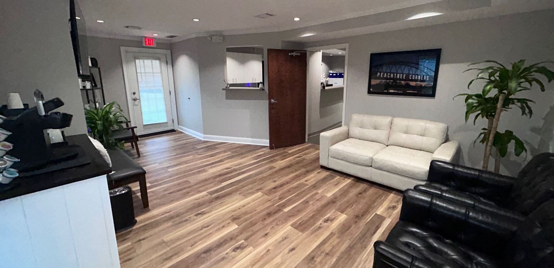 A living room with a couch and two chairs in it.