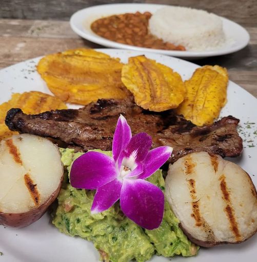 A plate of food with a purple flower on it