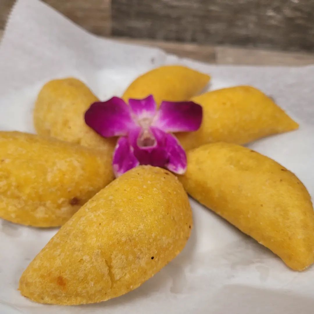 A plate of food with a purple flower on top