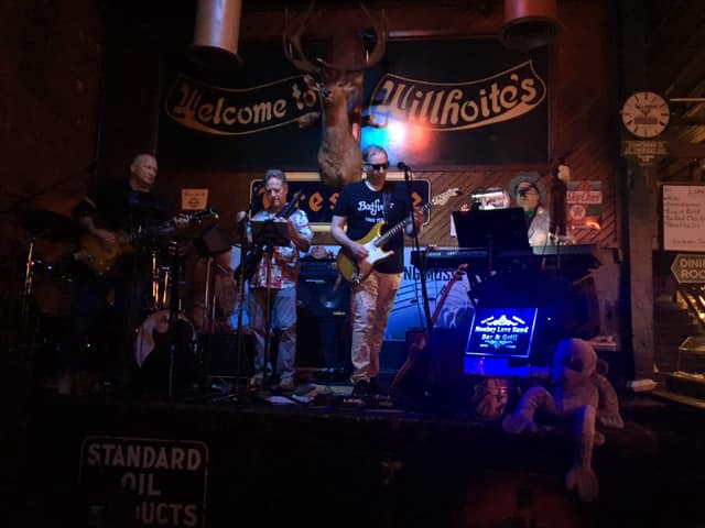 A group of people are playing instruments on a stage in a dark room.