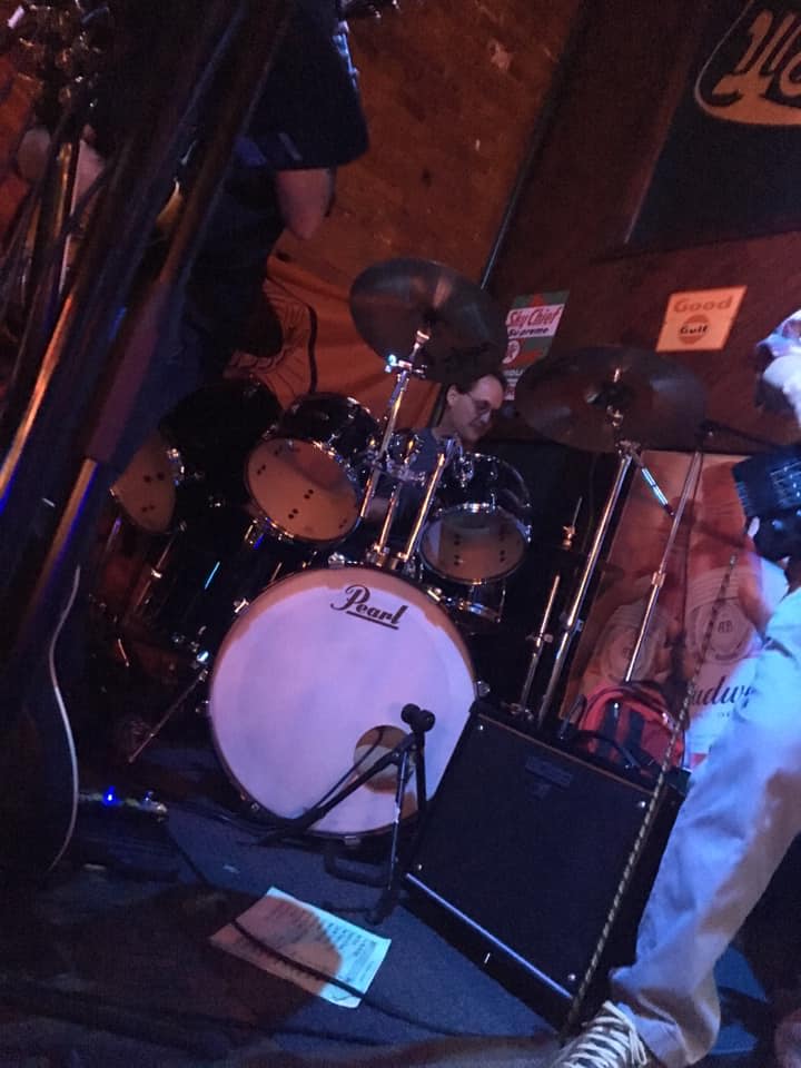 A man playing drums with a pearl drum in the foreground