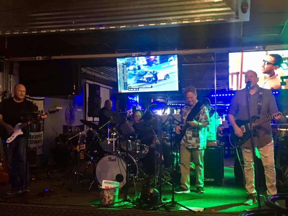 A group of men are standing on a stage playing instruments.