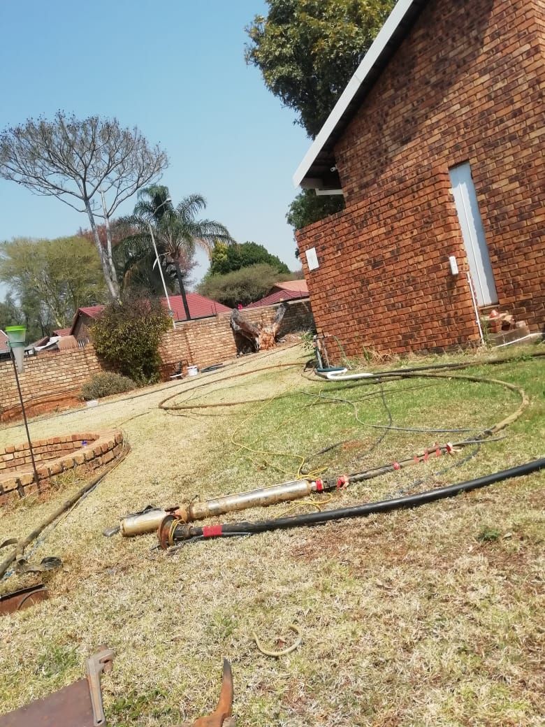 A brick building is sitting in the middle of a grassy field.