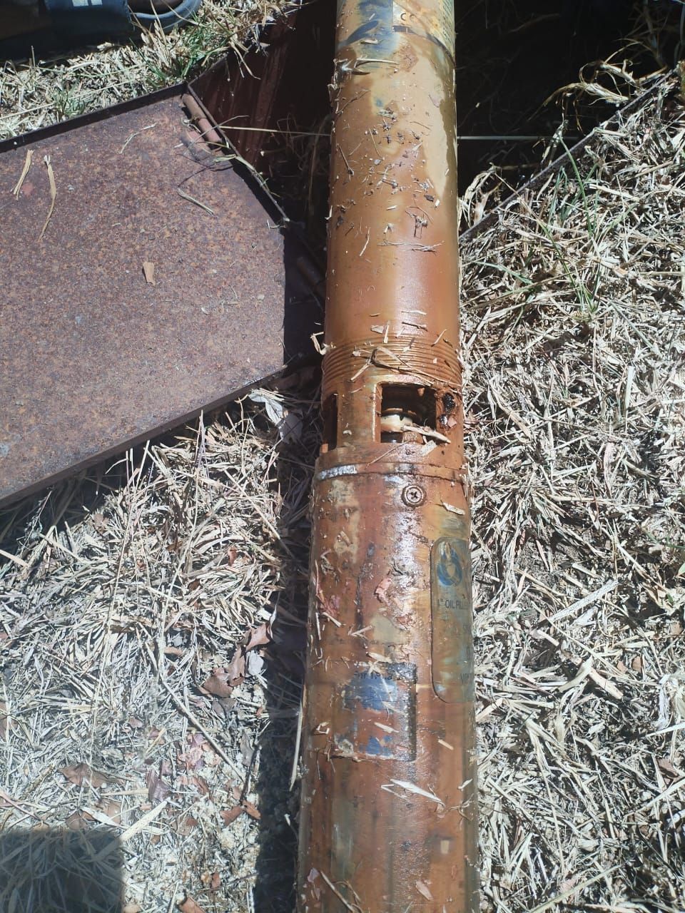 A rusty pipe with a hole in the middle of it