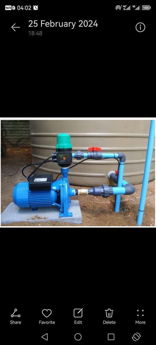 A blue water pump is sitting on top of a concrete platform.