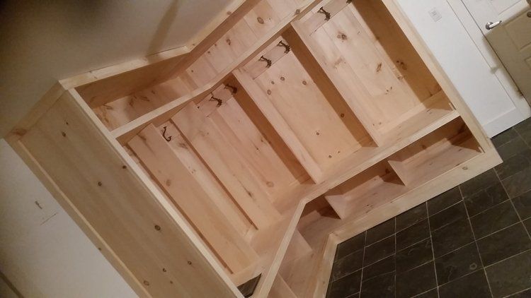 A wooden shelf is sitting on a tiled floor in a room.