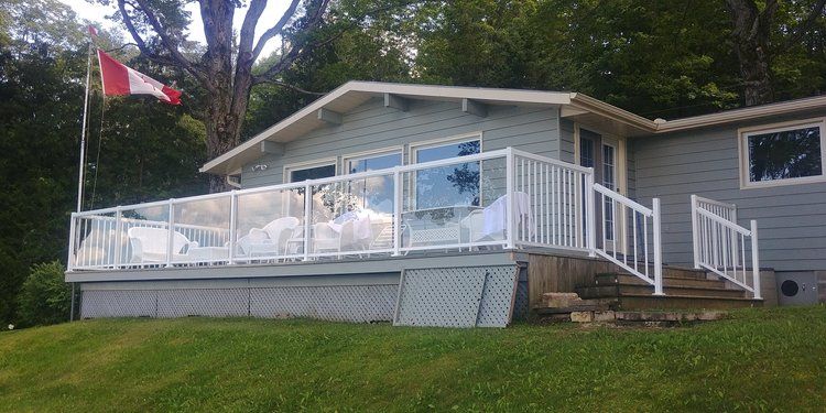 A house with a large deck and a canadian flag.
