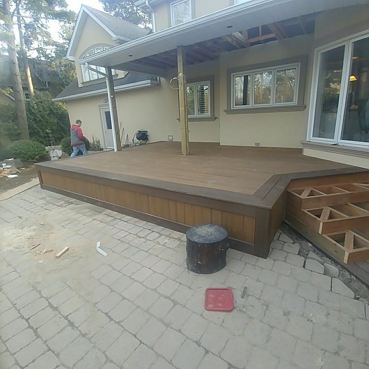 A wooden deck is being built in front of a house