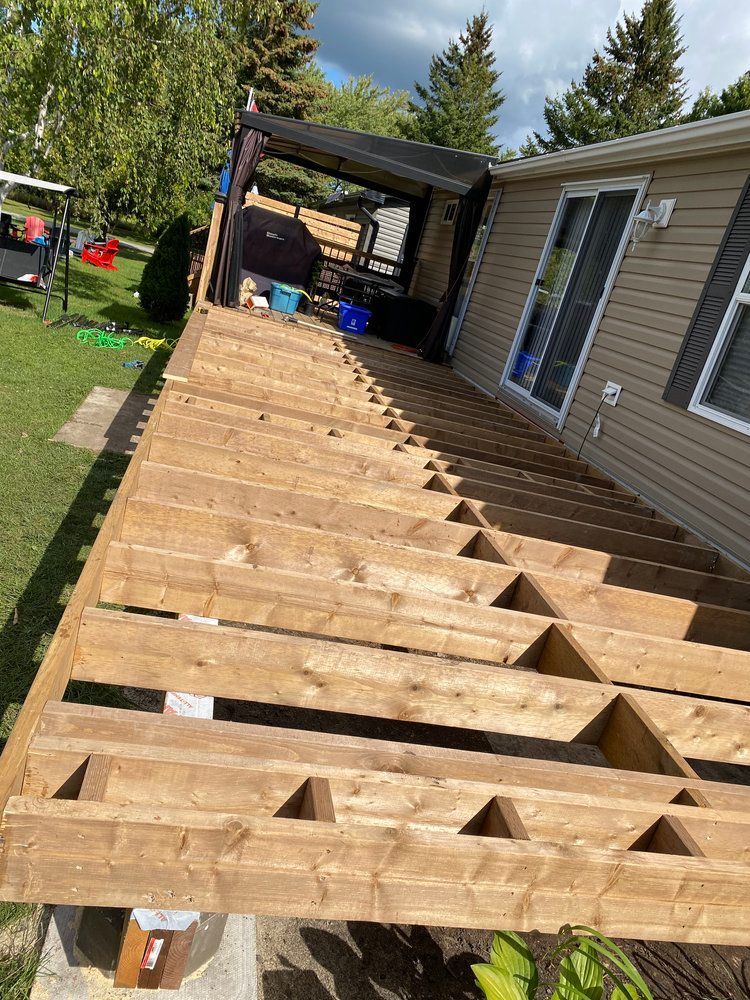 A wooden deck is being built on the side of a house.