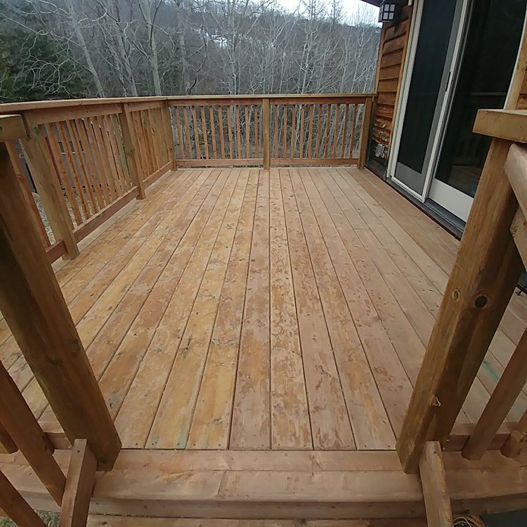 A wooden deck with a railing and a sliding glass door