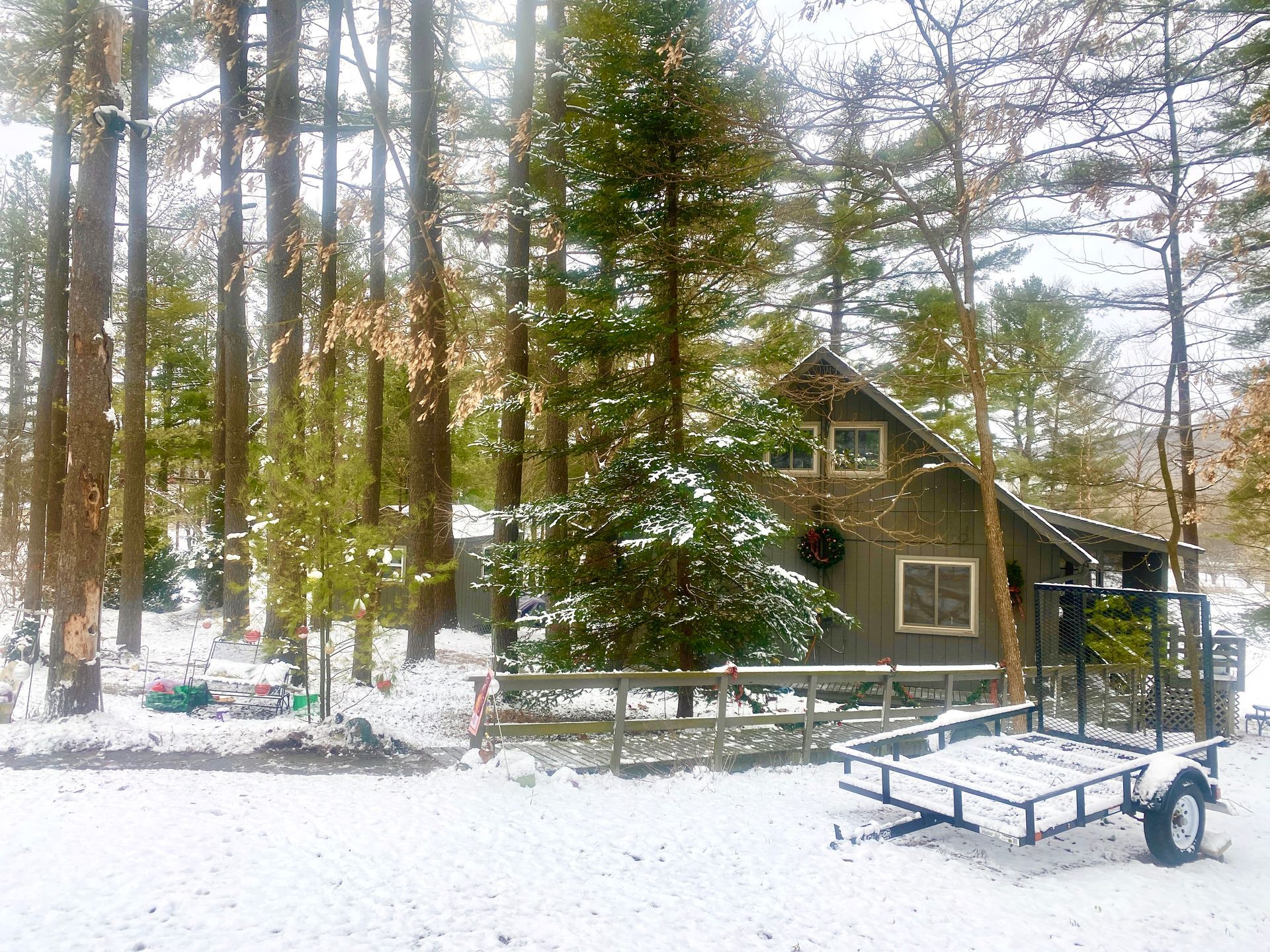 A snowy classic original cabin surrounded by trees in Hide-A-Way Hills Ohio
