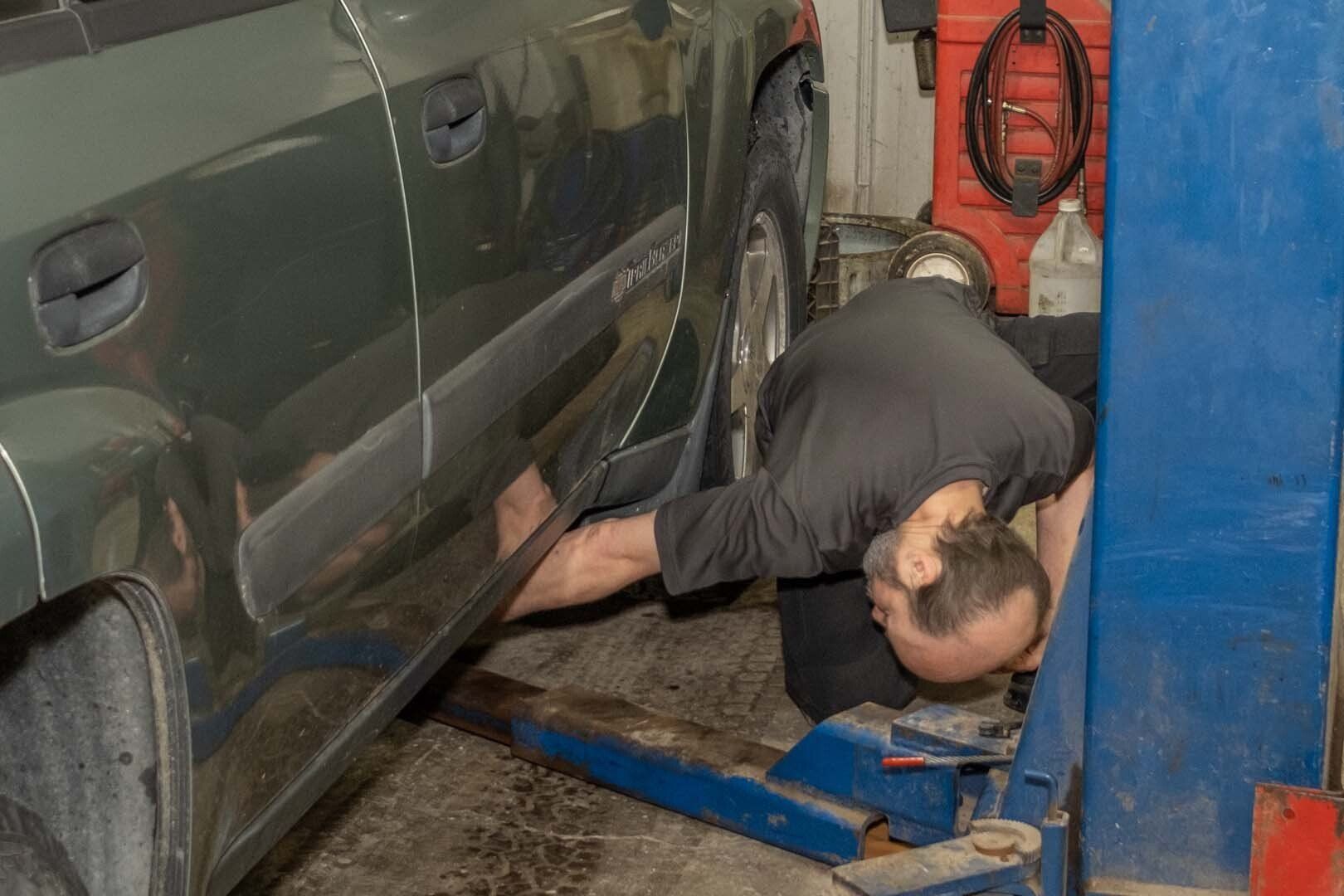 Our Mechanic is Working on a Car on a Lift in Clinton, MI - Phil's Complete Auto Repair
