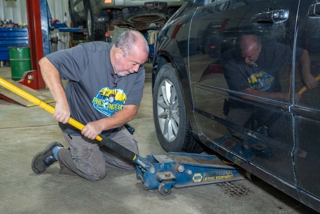Our Mechanic Lifts a Car With Jack - Phil's Complete Auto Repair