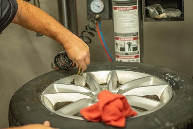 Our Technician Cleans Wheel in Clinton, MI - Phil's Complete Auto Repair