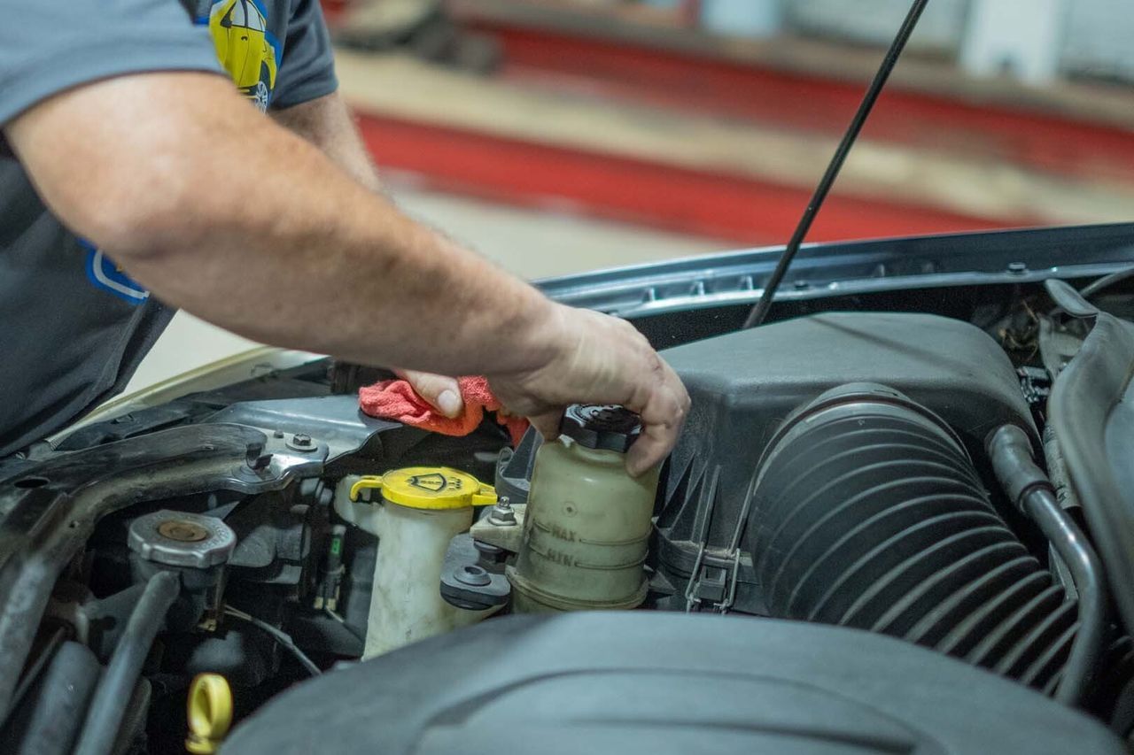 Our Technician Checks Fluid - Phil's Complete Auto Repair