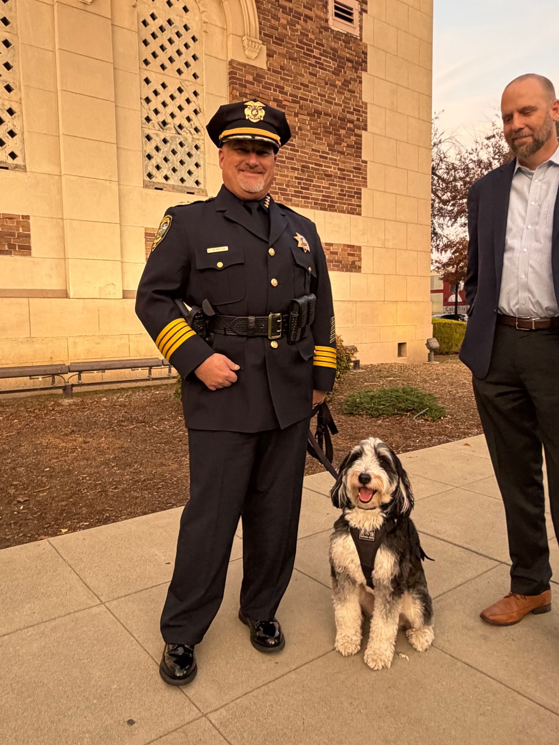 a police officer holding a puppy with the caption facility / peer support dogs