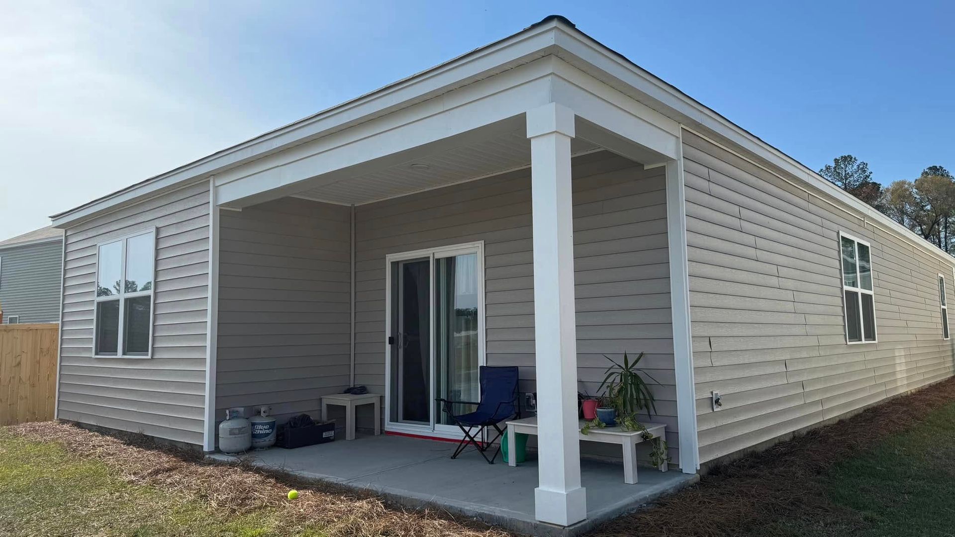 A small house with a porch and sliding glass doors.