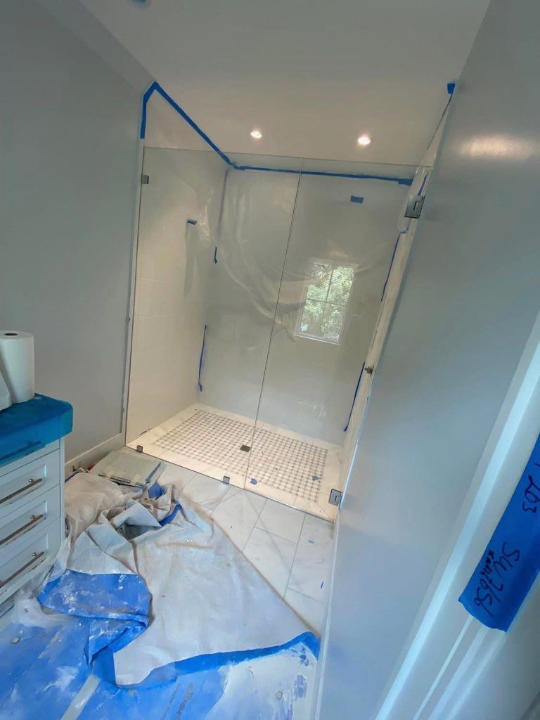 A bathroom with a walk in shower being painted white.