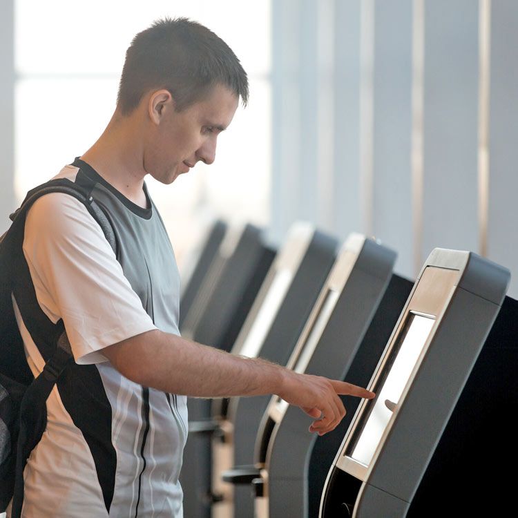 A man with a backpack is using a self service machine