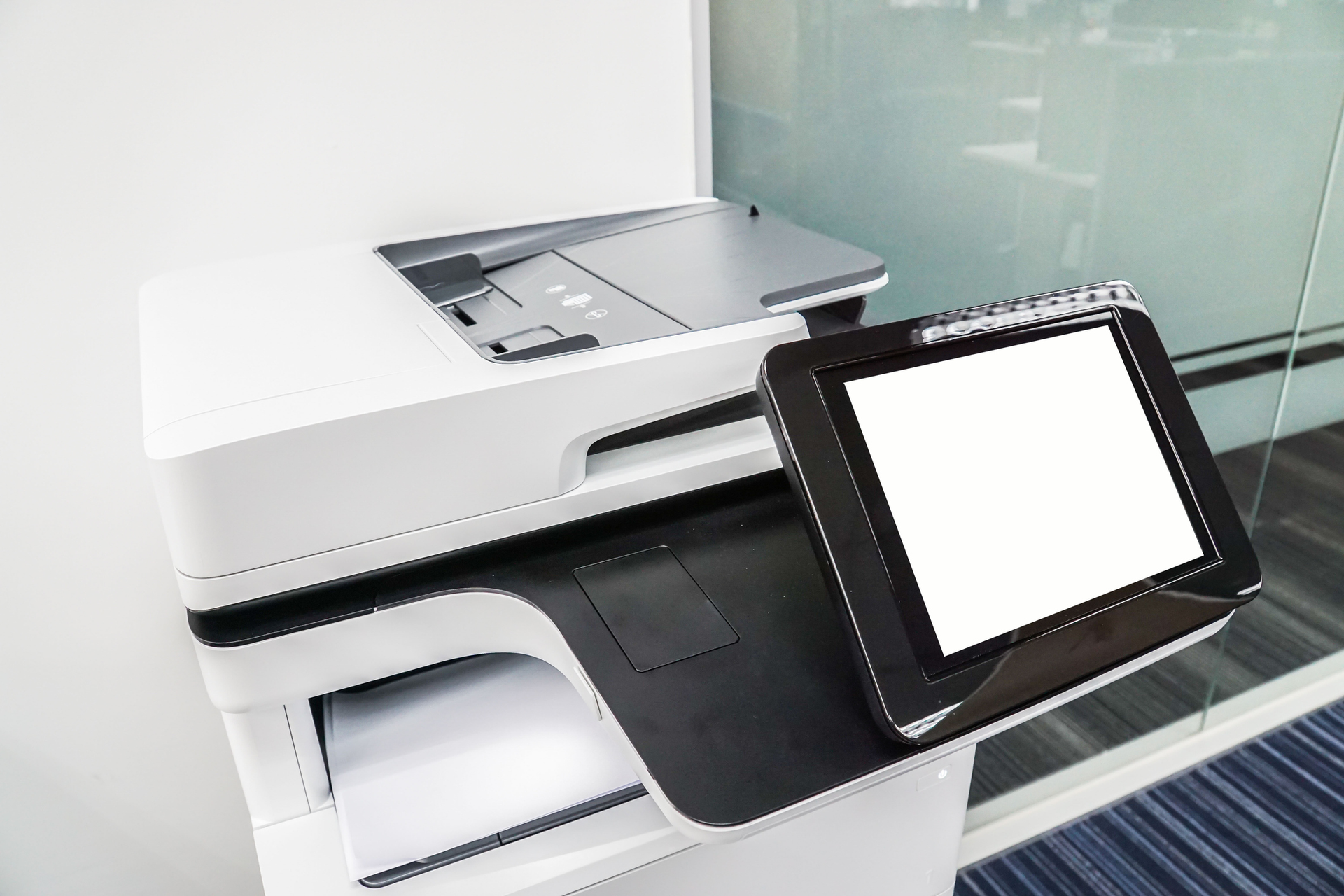 Modern office printer with touchscreen in bright corporate space for copier repair and maintenance.