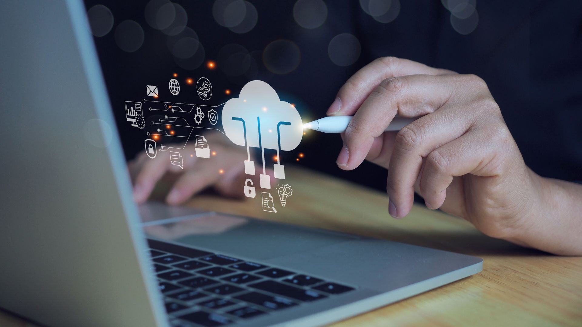 A person using a laptop with a stylus and floating cloud computing icons A person using a laptop with a stylus and floating cloud computing icons