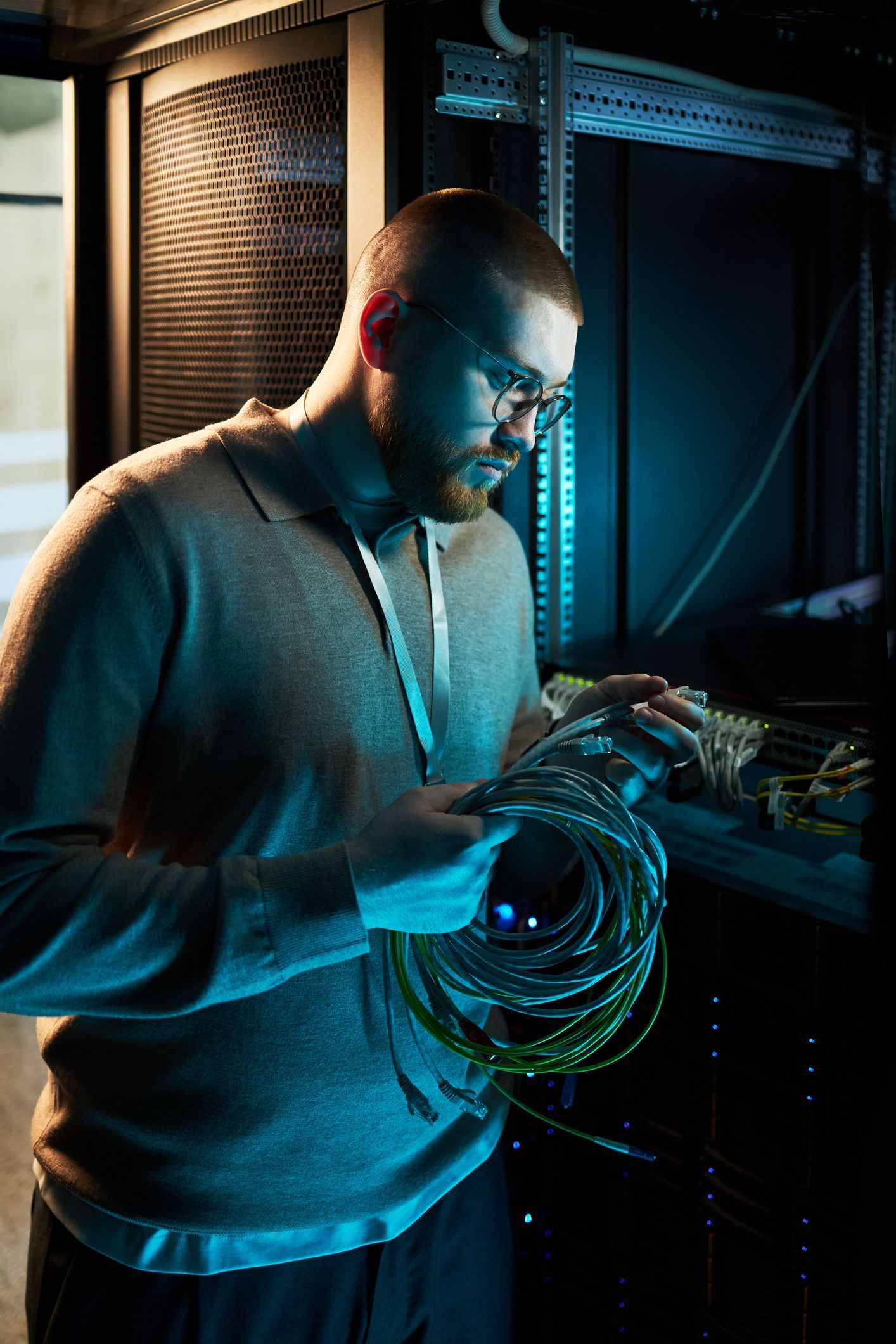 Technician managing server cables in data center. Technician managing server cables in data center.