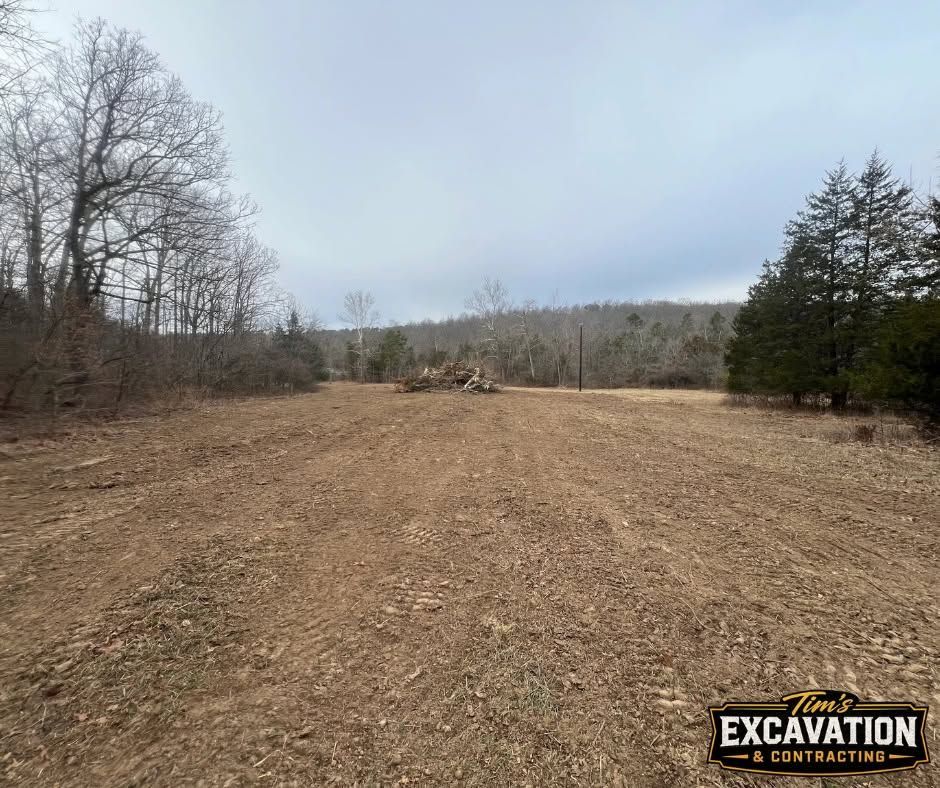 Cleared dirt lot with wood chips, bare trees, and an “EXCAVATION” sign in the lower right.