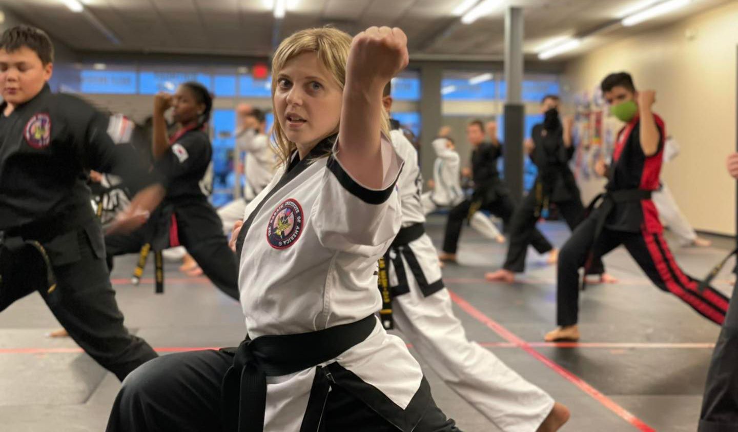 a girl in a karate uniform with the word taekwondo on it