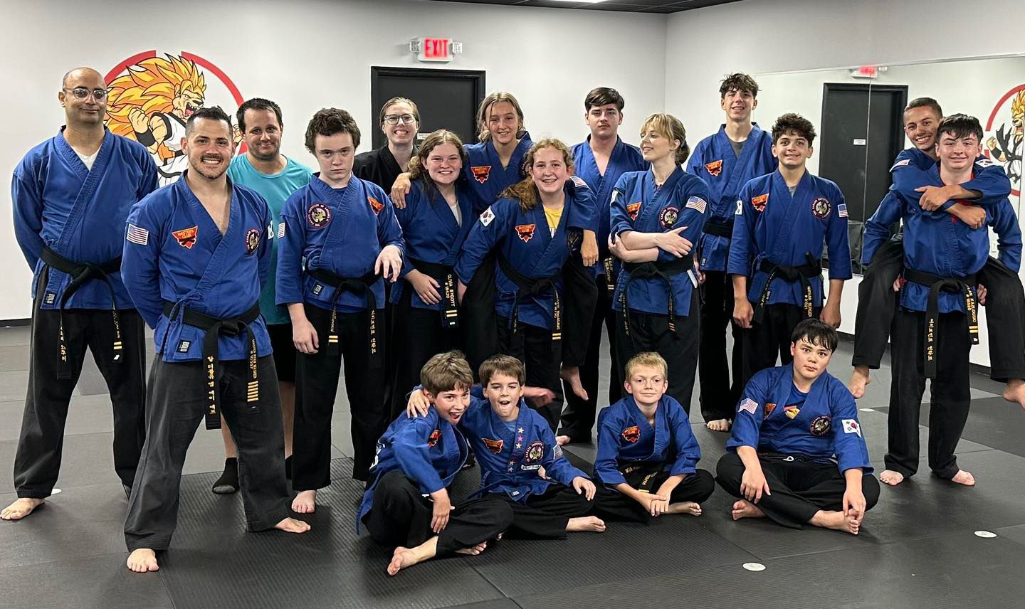 a group of people posing for a picture in front of an exit sign