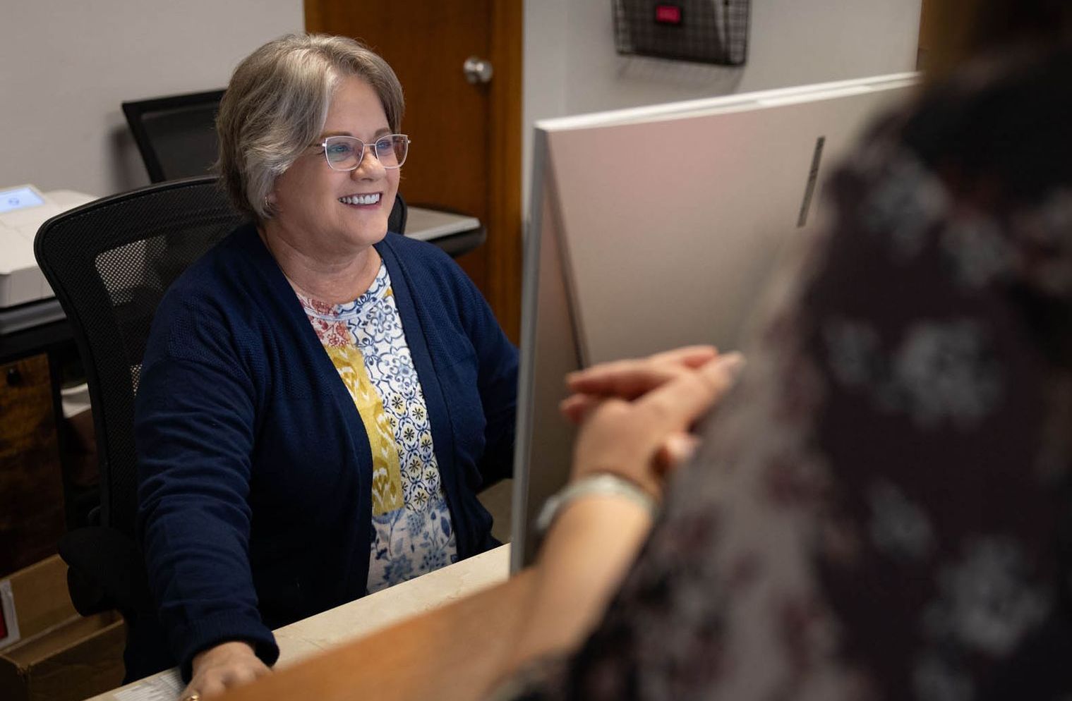 Patient Care Representative greeting patient. 