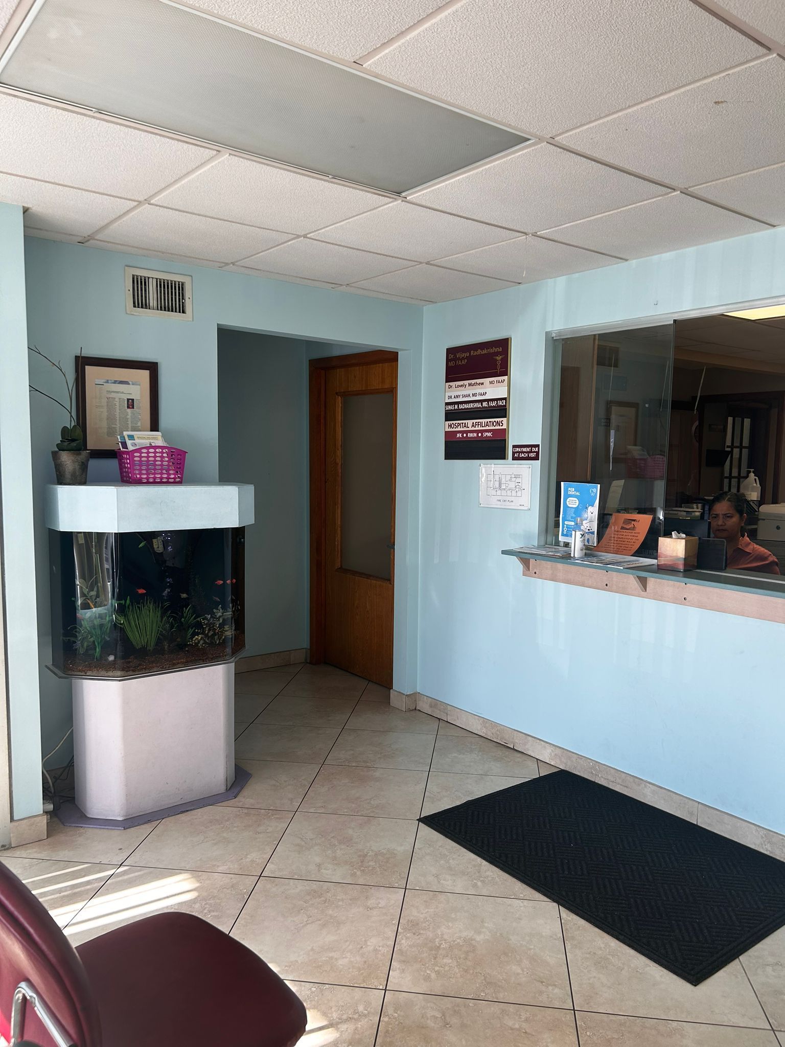 A waiting room with a fish tank in the middle of it