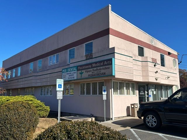 A large building with a car parked in front of it.