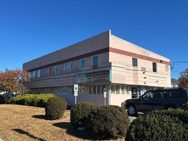 A large building with a car parked in front of it.
