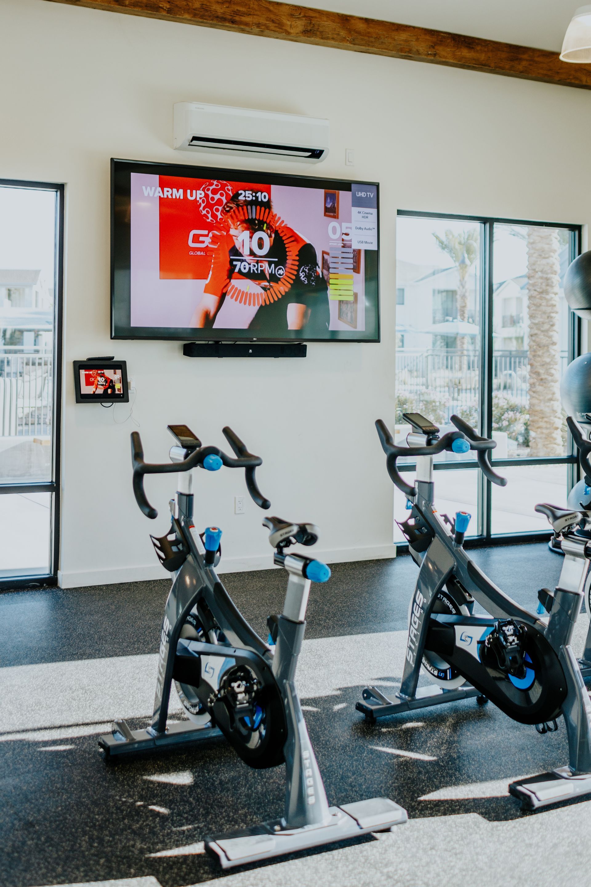 A gym with exercise bikes and a television on the wall.