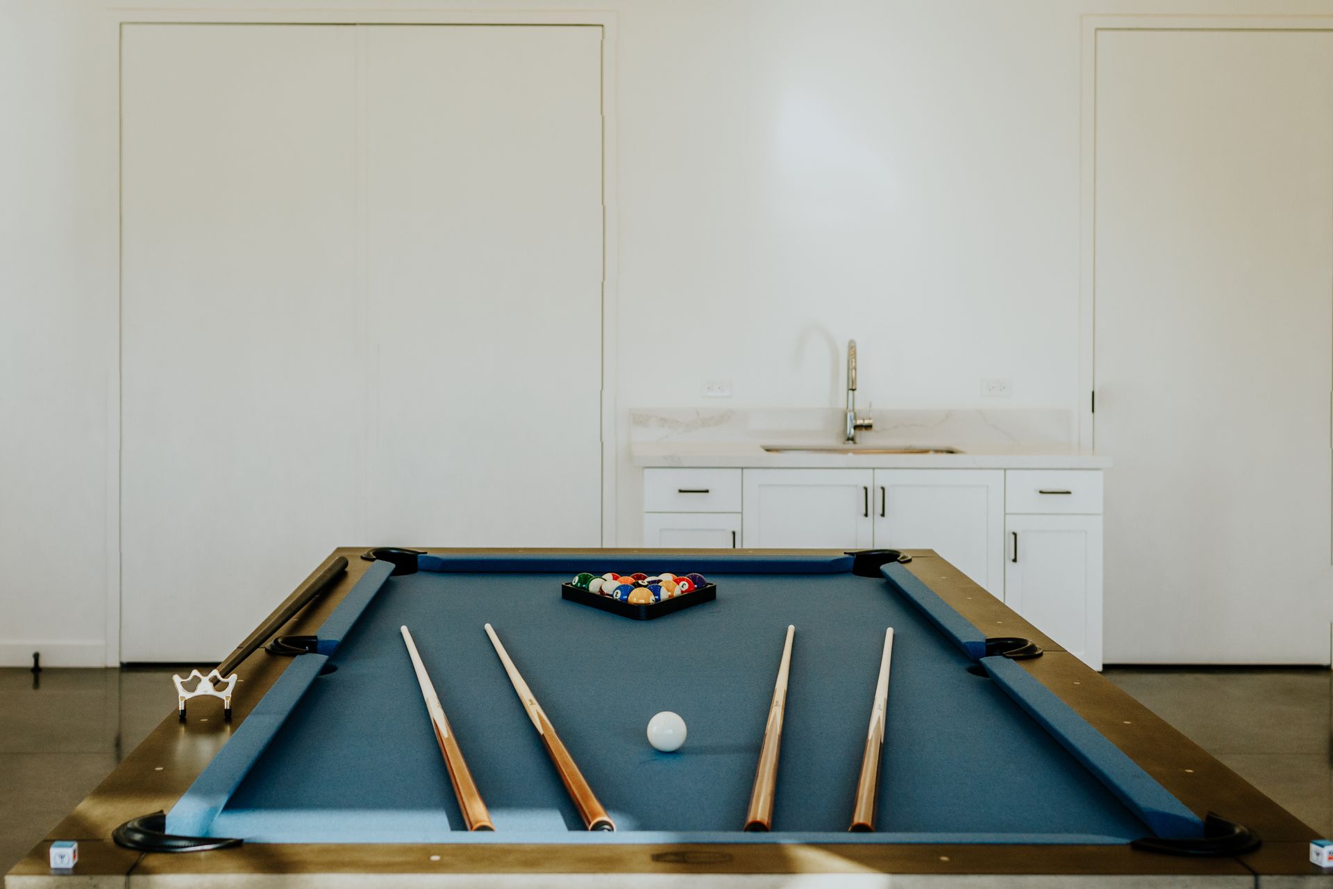 A pool table with cues and a ball on it