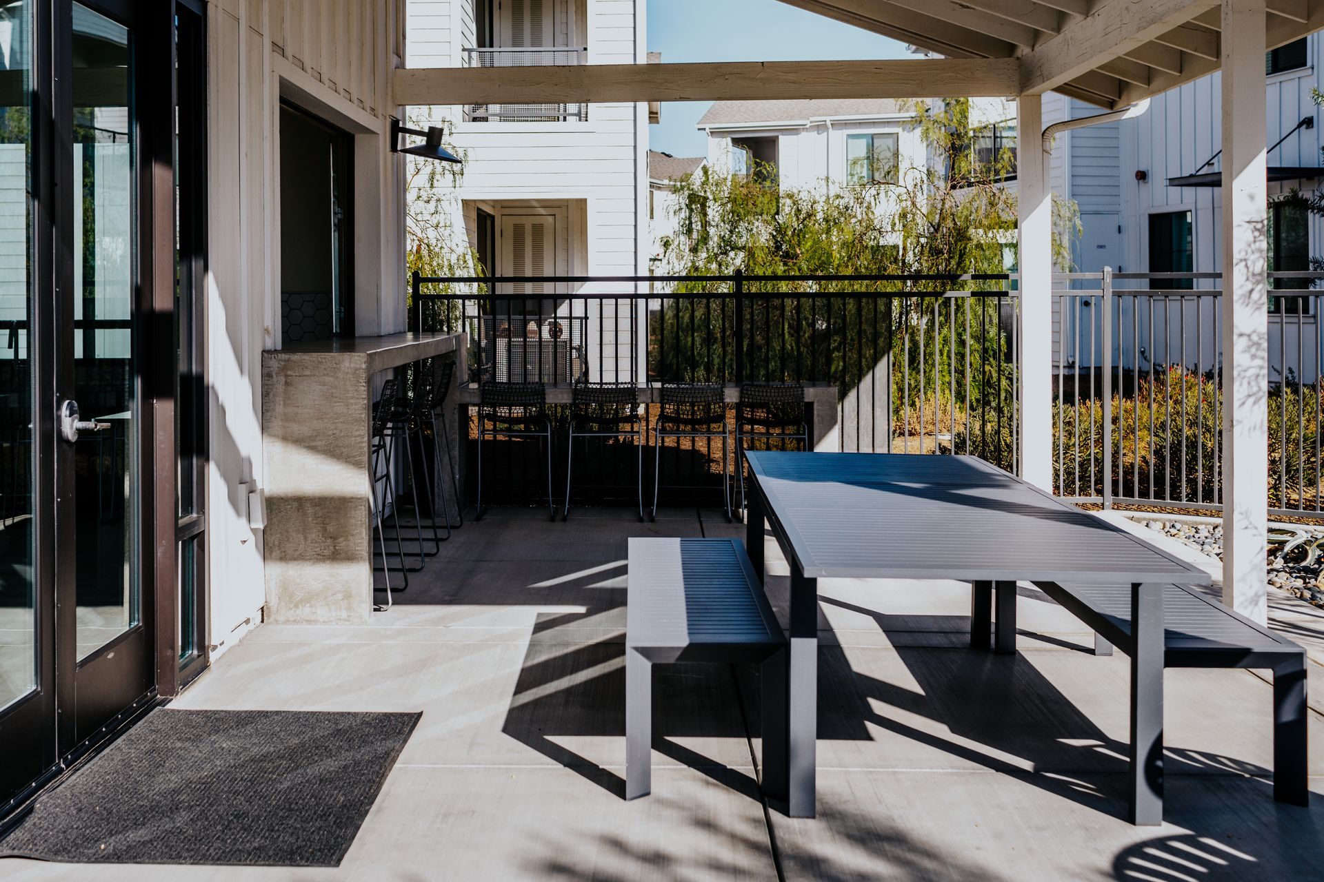 A patio with a table and benches under a canopy.