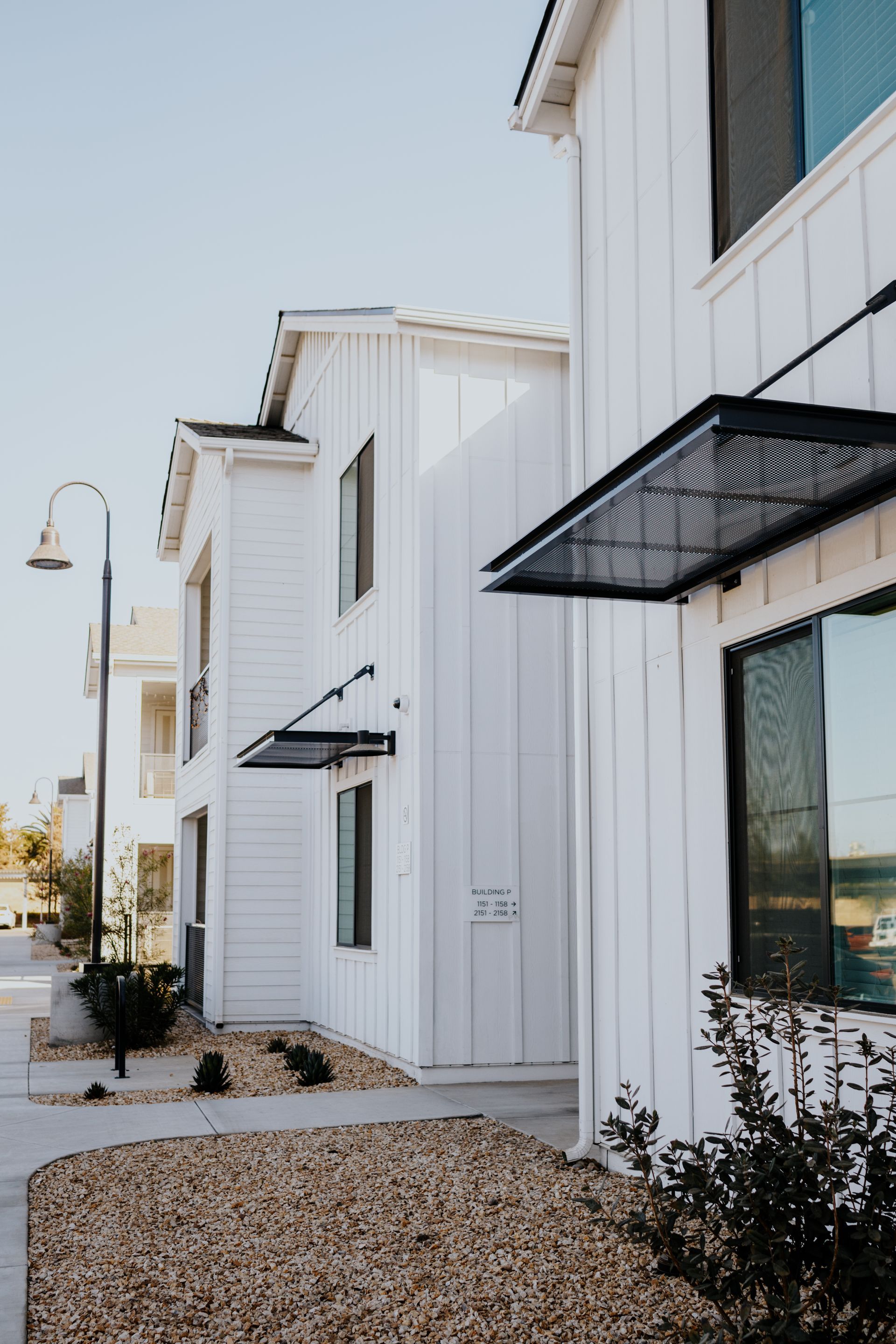 A white building with a black awning on the side of it.