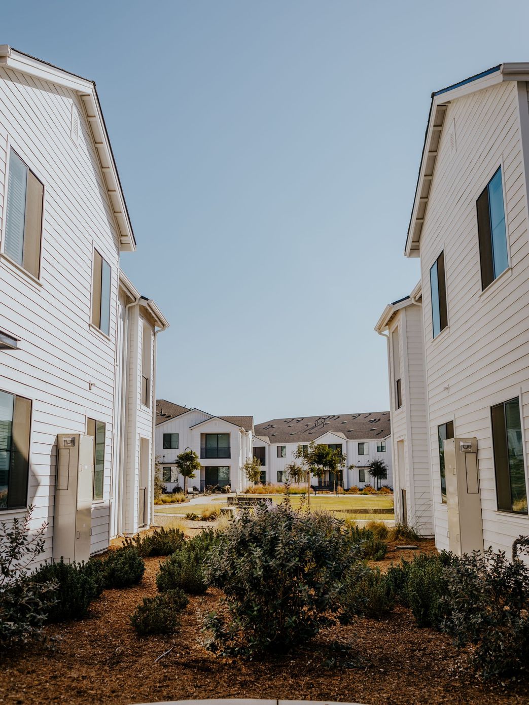 A group of white houses are sitting next to each other on a sunny day.