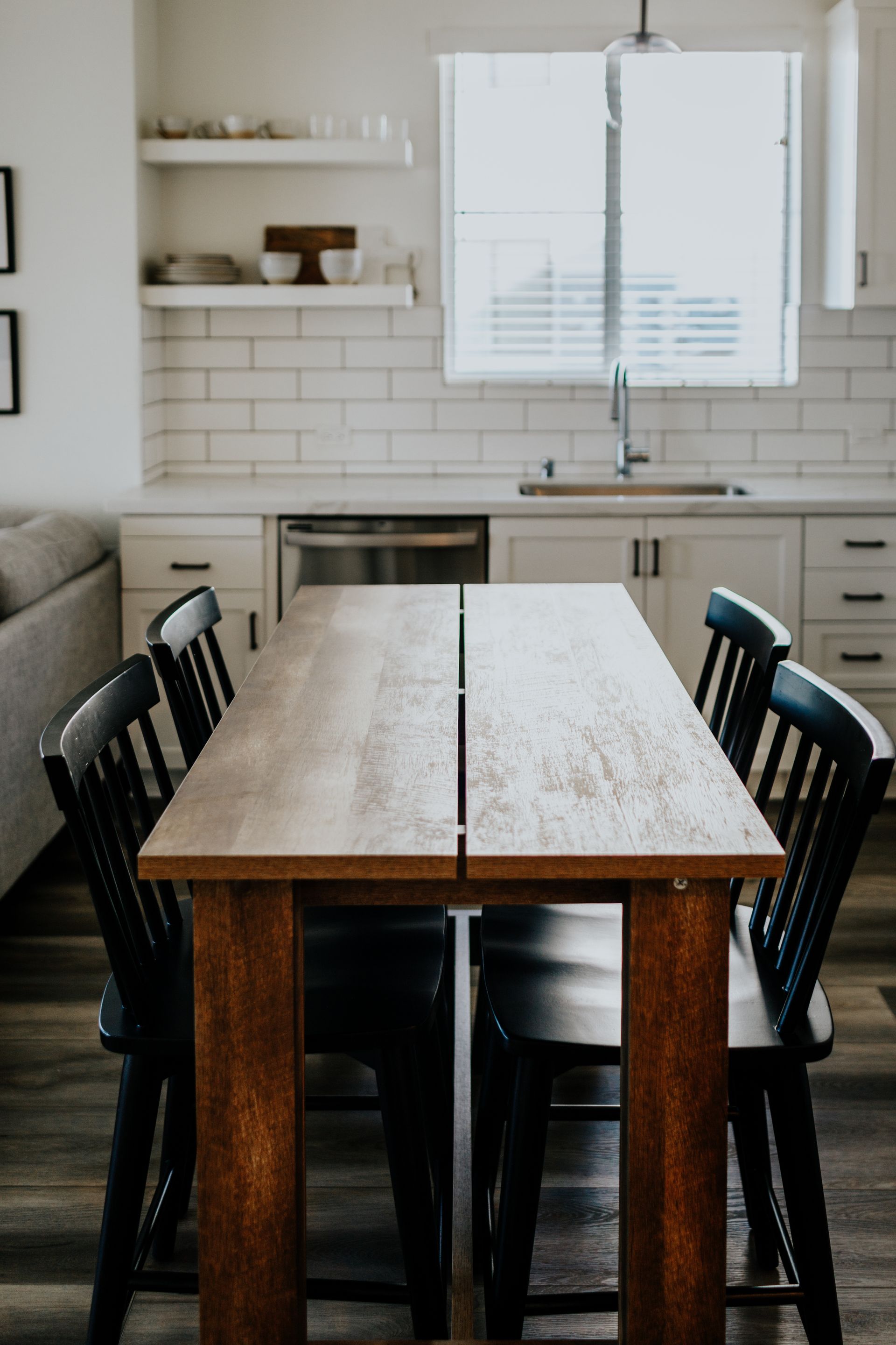A wooden dining table with black chairs.